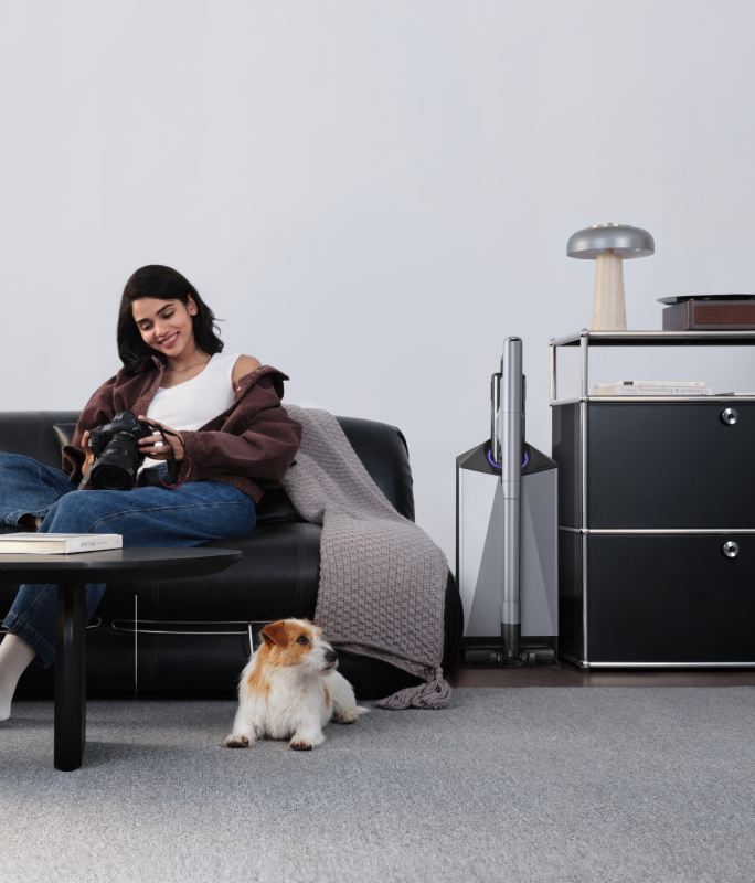 Narwal V50 Cube station beside a sofa with a woman and dog