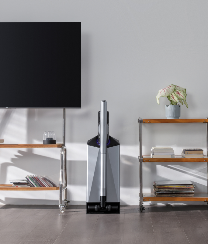 Narwal V50 Cube station between a TV and shelving in a bright living room